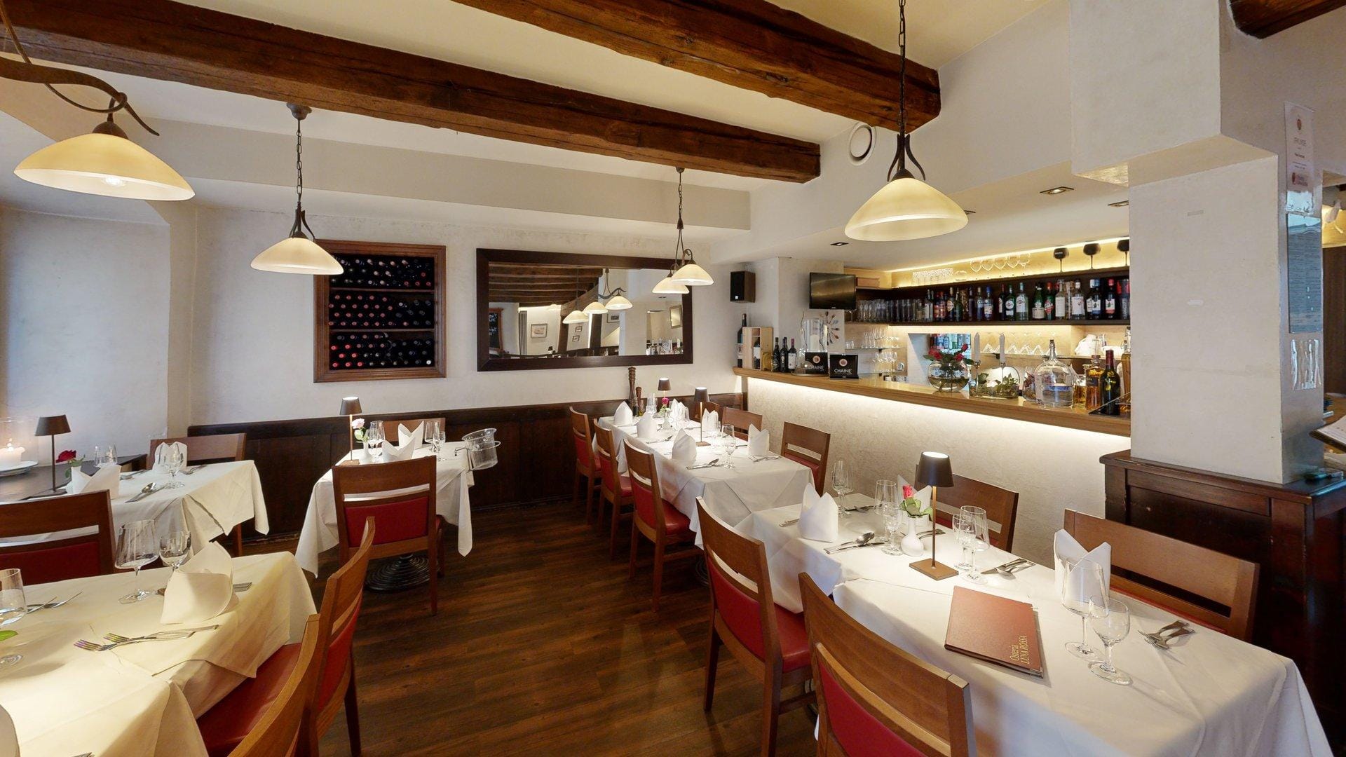 Gemütliche Ecke der Osteria Luna Rossa mit italienischem Weinregal